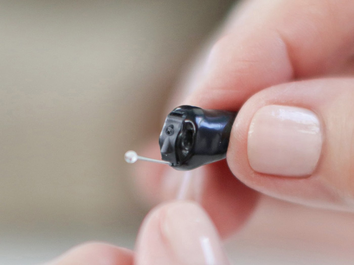 Starkey Signature CIC R held between finger and thumb