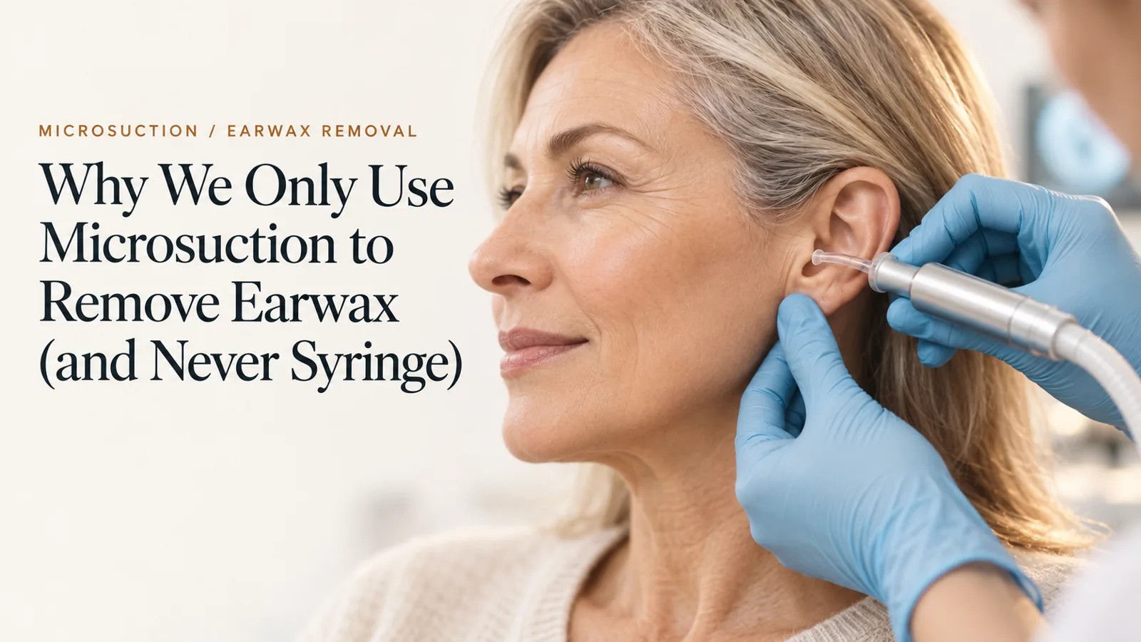 An audiologist in gloves gently removing earwax from an older woman's ear with a microsuction handpiece.